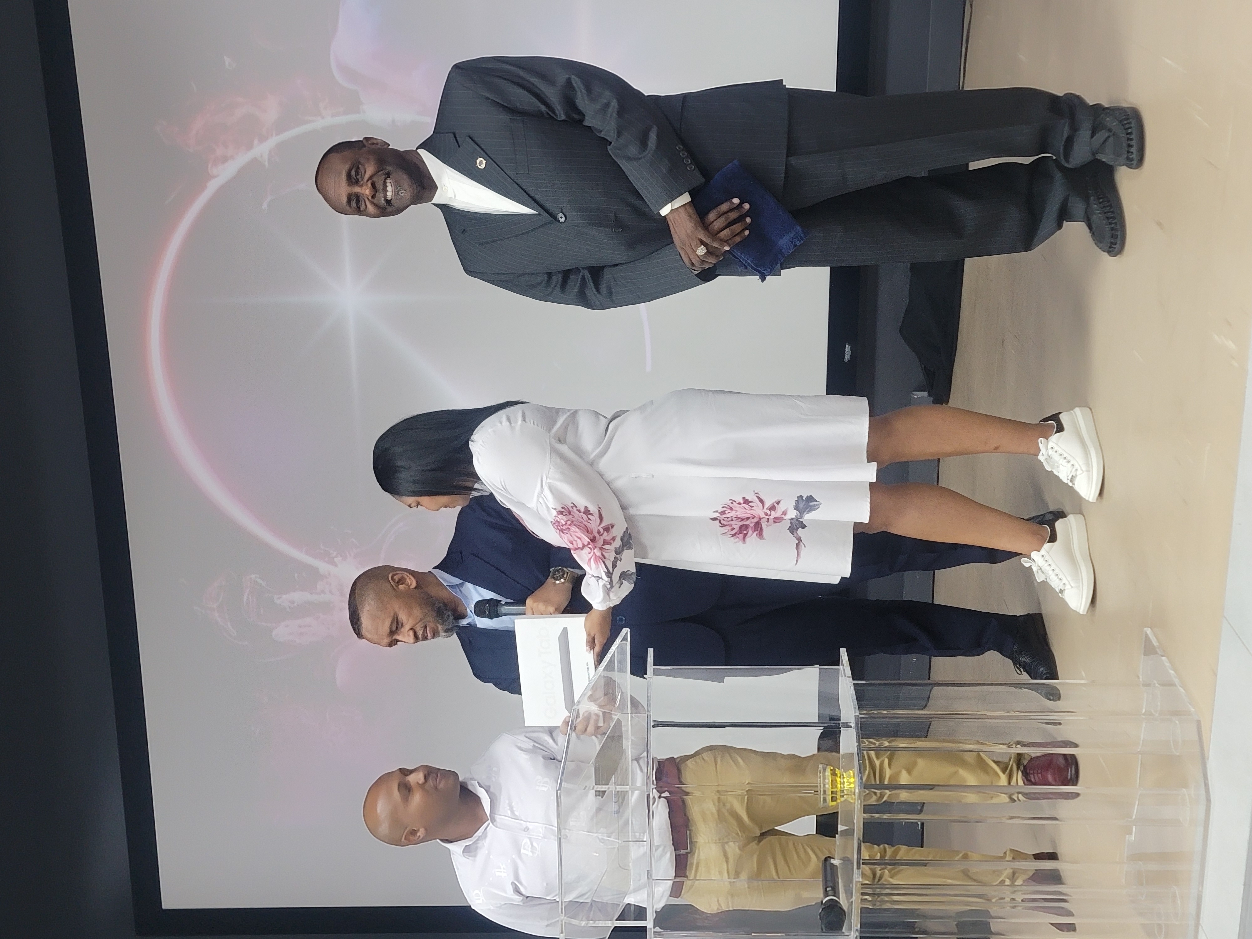 PUTS leader presenting a Samsung Galaxy tablet to a young woman on stage