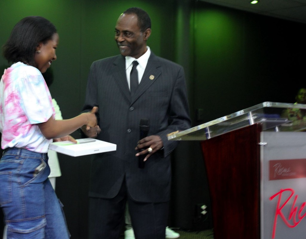 Community leader presenting a Samsung tablet to a smiling young woman with a handshake