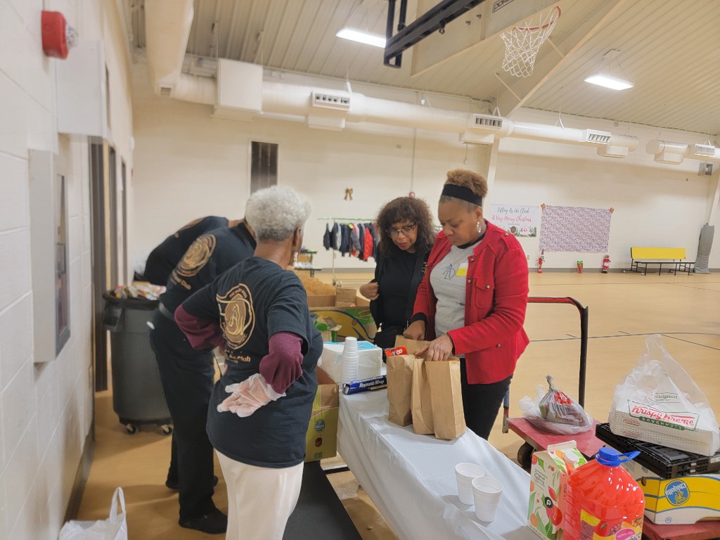 Volunteers packing gift bags in a gymnasium
